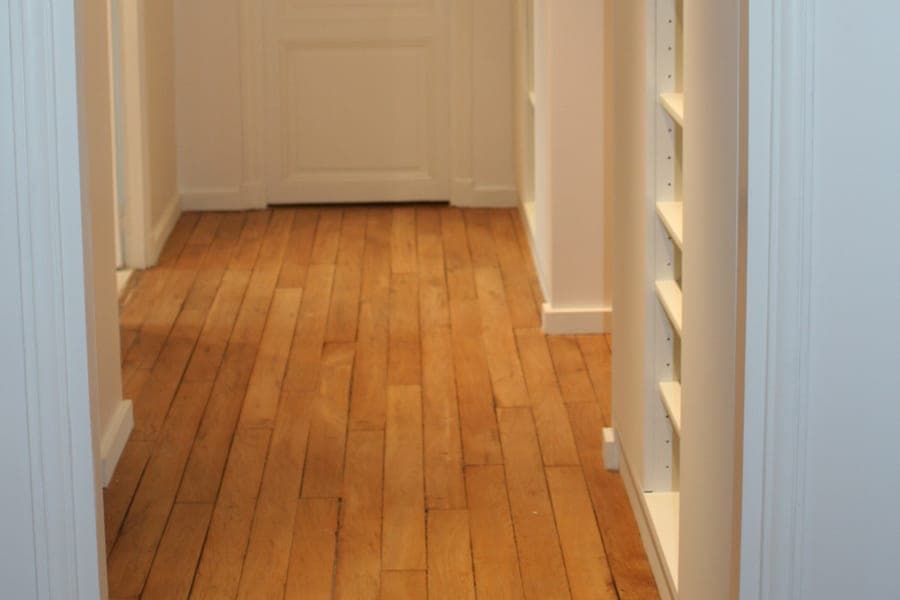 Parquet de chêne en lames dans un couloir aux rangements encastrés éclairés